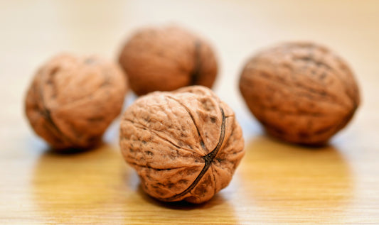 four whole walnuts on a table